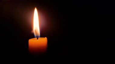 Burning a candle in the dark. The flames fade