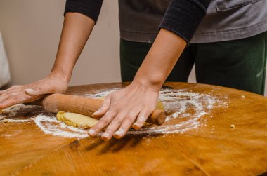 Rolling out cookie dough with a wooden splinter on table