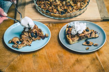 A piece of sweet cake with nuts, apples on blue plate