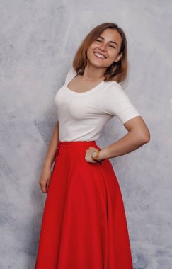 Portrait of cheerful girl, smiling ironically. Red skirt