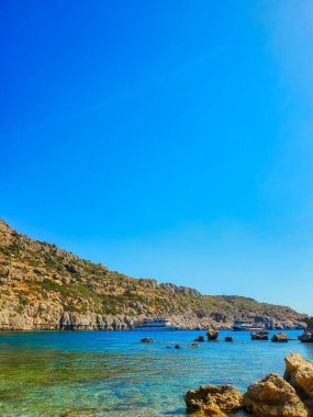Rocky seashore against blue sky.