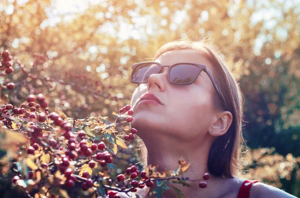 Kırmızı Böğürtlenli Ağaç Çalılarının Yanında Güneş Gözlüklü Güzel Bir Kadın — Stok fotoğraf