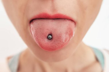 Piercingli kadın dili. Kozmetik salonu, açık kadın ağzı, yakın plan..