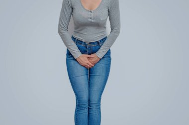 Kadın ellerini karnının aşağısına bastırmış, uterusta ağrı hissetmiş. Jinekolojik kavram