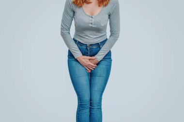 Kadın ellerini karnının aşağısına bastırmış, uterusta ağrı hissetmiş. Jinekolojik kavram