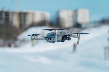 Mavi gökyüzüne karşı bir kuadkopter. Hava atışları, hava keşifleri