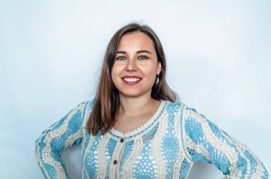 Koyu renk saçlı kadın samimi ve neşeli bir şekilde gülümser ve kameraya bakar. Parlak dişler. Beyaz arkaplan