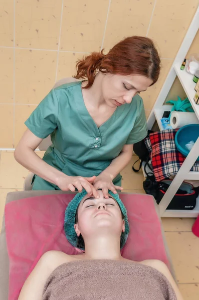 Frontvy Kosmetolog Masserar Kvinnans Ansikte Salongsvård Kosmetiska Förfaranden — Stockfoto