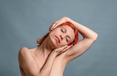 Kadın ellerini boynuna uzatıyor ve başını bir tarafa çeviriyor. Esneme, rahatlama.