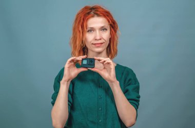 Çekici bir kadın elinde bir kamera tutuyor, kamerayla çekiyor..