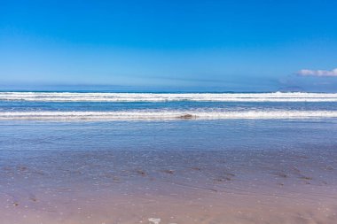 Beyaz deniz dalgaları kıyıya yuvarlanıyor. Deniz sakin manzarası.