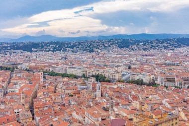 Deniz kıyısındaki evlerin manzarası. Dağların tepelerindeki şehir. Kümülüs bulutları ufukta.