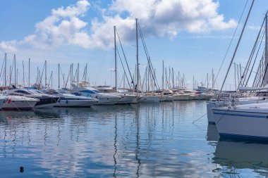 Panorama. Deniz limanı. Yatlar, tekneler, körfezdeki tekneler. Ufukta beyaz bulutlarla güneşli bir gün