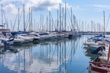 Panorama. Deniz limanı. Yatlar, tekneler, körfezdeki tekneler. Ufukta beyaz bulutlarla güneşli bir gün