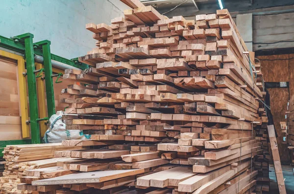 The boards are stacked in a pile in carpentry shop