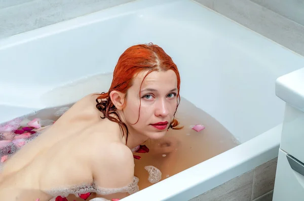 一个有诱惑力的女人在浴室里洗澡水 回头看着摄像机看着观众 — 图库照片