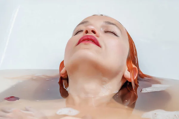 一个漂亮女人的脸浸在洗澡水里 — 图库照片
