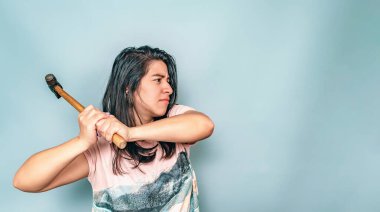 Beyaz gömlekli kadın çekiç sallıyor. Çekiçli agresif bir kadın. İspanyol.