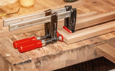 Marangoz kıskaçları tahtalara sabitlendi. Atölyeye marangoz yapıştırma