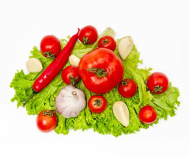 Domates, biber, sarımsak, salata yaprakları. Vejetaryen diyet yemekleri, beyaza izole edilmiş yaratıcı kompozisyon.