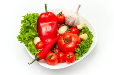 Su damlalarıyla dolu bir kasede nefis sebze salatası. Domates, marul, sarımsak, kırmızı biber, tatlı biber