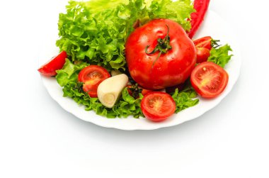 Beyaz arka planda kasede nefis sebze salatası. Doğranmış domates, marul, sarımsak