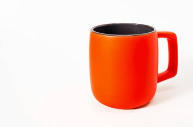 Large orange ceramic mug isolated on white background. Dark middle. Copy space
