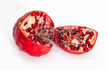 Spoiled red pomegranate with mold. Cut into two pieces. White background, isolated