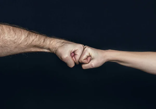 Man and woman are fist bumping. Fist Bump. Clash of two fists, vs. Gesture of giving respect or approval. Friends greeting. Teamwork and friendship. Partnership concept.