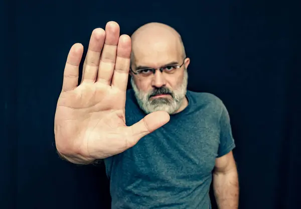 A man with a gray beard put out his palm and stopped. Stop Man Gesture