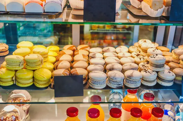 Sweets, cakes of different colors in the window of cafe store