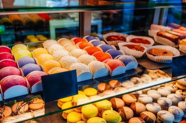 Sweets, cakes of different colors in the window of cafe store