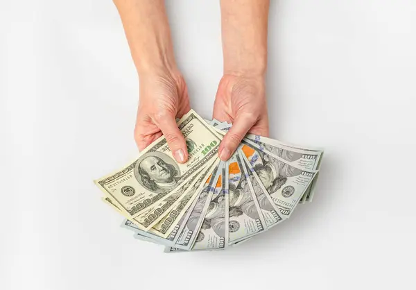 Female hands with fan of dollar bills. View from above. Concept of payments, financial stability
