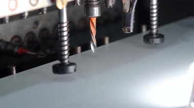 Mobilya üretiminde sondaj makinesiyle beyaz mobilya tahtasında delikler açmak.