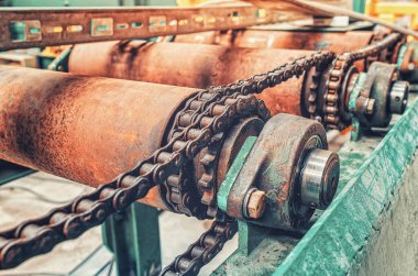 Eski kırık şanzımanın aşınmış parçaları. Yakın plan. Paslı metal zincir, şanzıman şaftları.