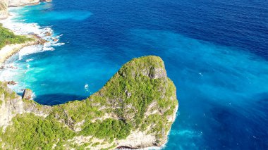 İnanılmaz kaya ve deniz manzarası. Beyaz dalga köpüğü kayalara çarpar. Nusa Penida Endonezya
