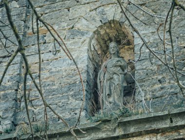 Taş kilise duvarında antik kadın heykeli. Dini bir geçmişi var. Hıristiyan mimarisi