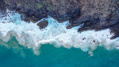 İnanılmaz kaya ve deniz manzarası. Beyaz dalga köpüğü kayalara çarpıyor. Nusa Penida, Endonezya