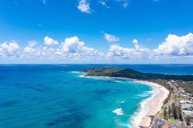 Çevresindeki binalar, dalgalar, sahil ve dağlar boyunca insansız hava aracı fotoğrafı.