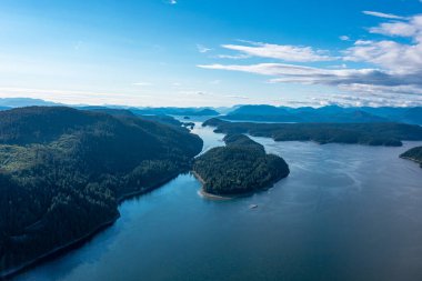 İnsansız hava aracı arka plandaki dağlara karşı sudaki ormanlı adaları çekiyor. Klungkung Endonezya