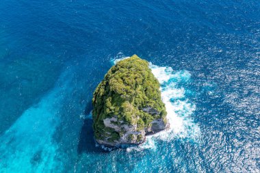 Drone 'dan yapayalnız rock. Tropik yeşillik, okyanus, kayalar. Tatilde. Klungkung, Bali, Endonezya.