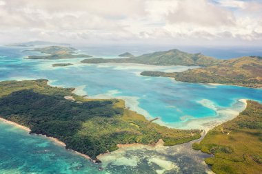 Yeşil okyanus sularının insansız hava aracı görüntüsü. Cumulus, Fiji Adaları üzerinde bulutlar oluşturuyor. Tatil ve seyahat kavramı.