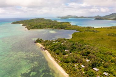 Turkuaz okyanus suları bulutların altında. Uzakta dağlar var. Fiji Adalarının İHA görüntüsü.