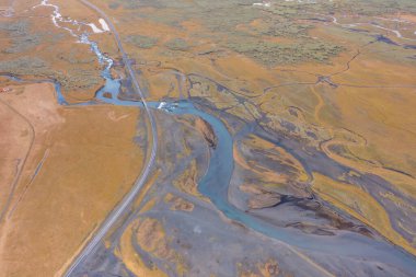 Volkanik bataklıklar kanyonunda donmuş lav ve yosun ile yol. Vadideki nehir. İzlanda 'nın Doğusu