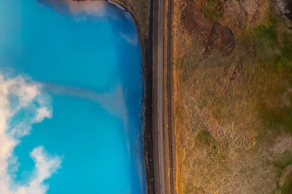 Top drone shot through clouds of blue lake in the marshes. Myvatn, Iceland, Northeast region.
