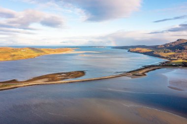 İskoçya Dağları 'ndaki bulutlarla kaplı dağlara bakan nehir manzaralı drone manzarası.
