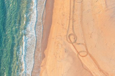 Deniz kenarındaki kumlu sahil, sahilin kuş bakışı görüntüsü.
