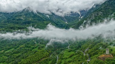 Dağ manzarası, yeşil Alp dağlarının üzerinde beyaz bulutlar.