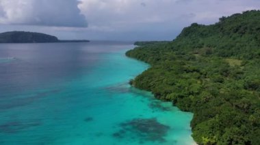 Mavi bulutların altında turkuaz deniz kıyısında yeşil kıyıların robot videosu. Tropik cennet. Sanma, Vanuatu