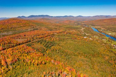 Sonbahar renkli orman, mavi nehir, ufukta dağlar. New Hampshire, ABD. Drone fotoğrafı.